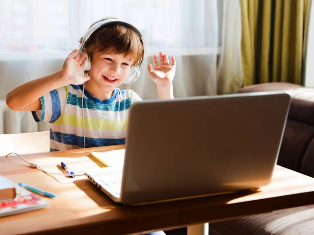 Niño feliz frente a la computadora